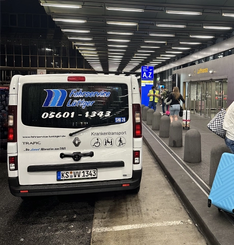 Auto von Fahrservice Lüttger am Flughafen, Person mit Koffer im Vordergrund